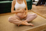 A pregnant woman touching her baby pump