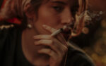 Pensive woman in headscarf smoking cigarette
