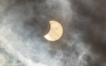 Solar eclipse in the cloudy sky