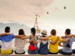 people holding shoulders sitting on wall