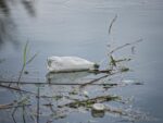 polluted river with floating plastic waste
